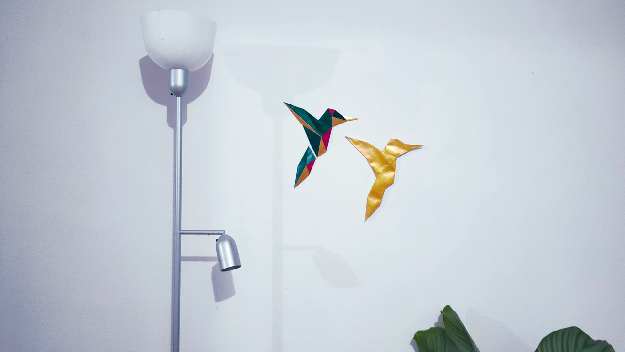 Papercraft colibri peint fixé sur mur